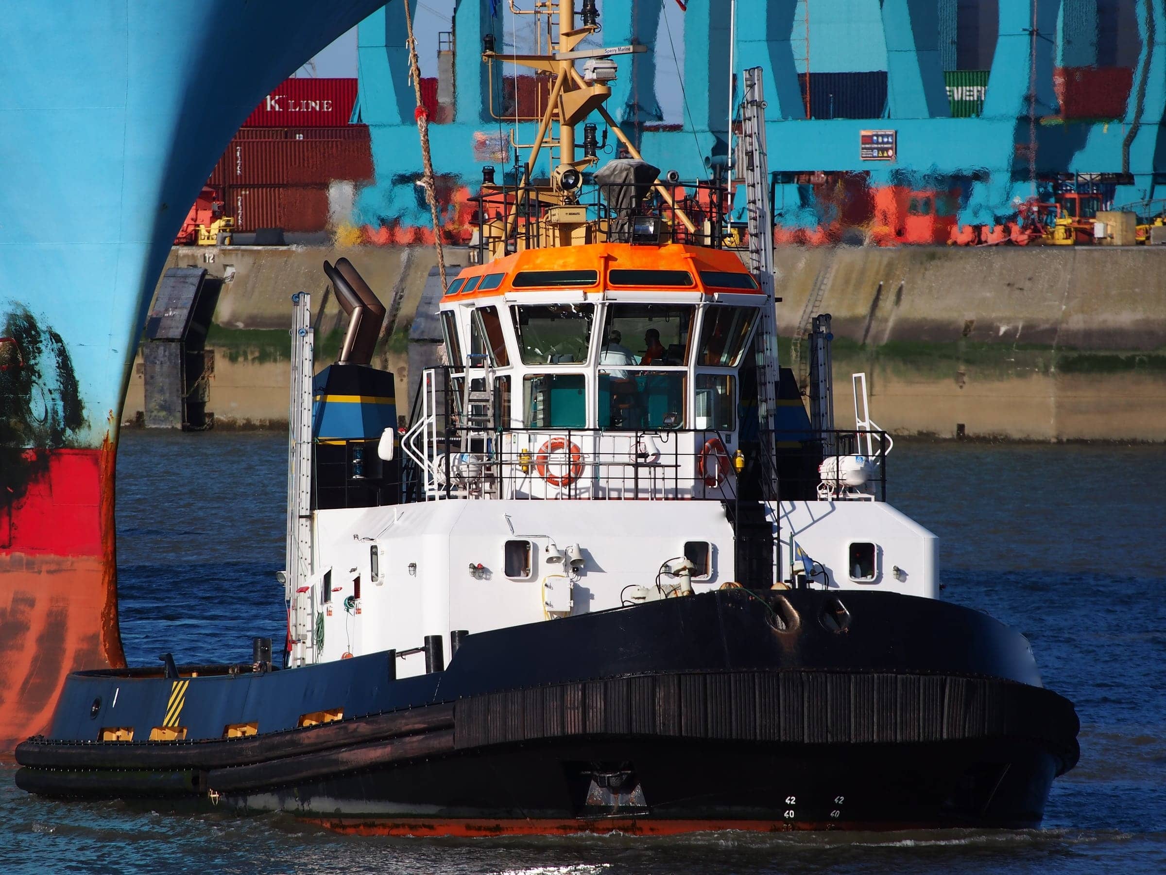 Tug assisting a container ship in port